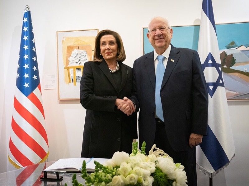 U.S. House Speaker Nancy Pelosi shaking hands with Israeli President Reuven Rivlin between the American and Israeli flags