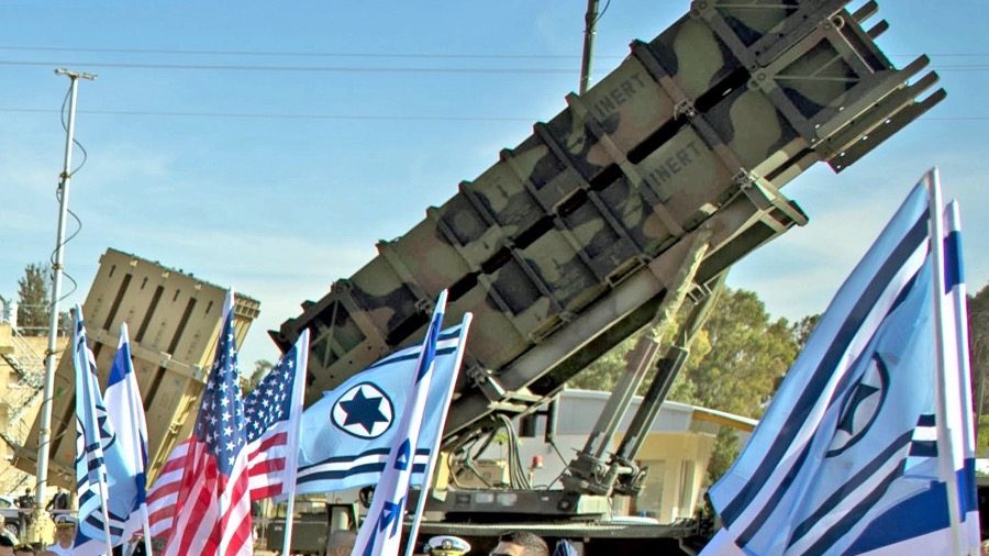 A U.S. Patriot missile launcher and an Israeli Iron Dome battery flanked by U.S. and Israeli flags